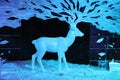 Ice figure of a reindeer with large branching horns turning into the Northern lights