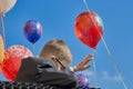 Russia, Saint-Petersburg, September 2019: a boy with glasses waves his hand against the background of balloons back to school