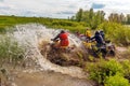 A group of men on quad bikes overcomes water obstacles. Cross-country tours