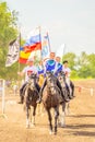 Russian young Cossacks gallop with banners on horses in summer sunny day.