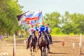 Russian young Cossacks gallop with banners on horses in summer sunny day.