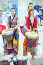 Festival Plasticine rain. Girls in ethnic clothes beat the tomts in the drum