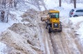 Grader clears the road from snow during a snowfall