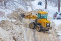 Grader clears the road from snow during a snowfall