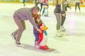 A young father with a child skating on the rink