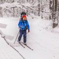 A skier runs along a ski track with a child in a backpack