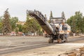 Cutting old asphalt with a special machine and loading it into a dump truck Royalty Free Stock Photo
