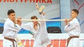 Demonstration performances of karate players, sportsman smashes wooden stick with a kick of his foot