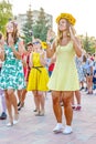 dancing beautiful and elegant stylish girls participating in the carnival costumed women`s bike ride in the summer evening