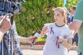 journalists interview an young beautiful volunteer girl on the Volga embankment in a warm summer sunny day. Text in Russian: sama