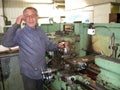 a worker works on a lathe in a Soviet era machine shop Royalty Free Stock Photo