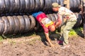 athletic youth participates in a race of heroes and overcomes obstacles car tires on a summer day in the village of Roshchinsky . Royalty Free Stock Photo