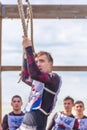 a young athlete, a participant in the race of heroes, overcomes the track on the rings. Text in Russian: cadet, race of heroes