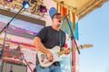 A young man plays the guitar on the open summer stage Royalty Free Stock Photo