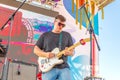 A young man plays the guitar on the open summer stage Royalty Free Stock Photo