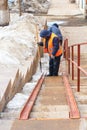 Workers of the communal service clear the pedestrian ladder from the accumulated snow