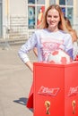 beautiful blond girl posing near a soccer ball for the 2018 World Cup on Leningradskaya Street on a sunny day