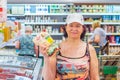 Beautiful mature women showing a pack of mayonnaise at the grocery store