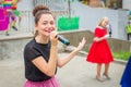 A beautiful school graduate sings a song for her classmates.