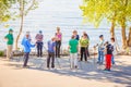 a group of older people studying Scandinavian walking on the Volga River Embankment on a summer sunny day Royalty Free Stock Photo