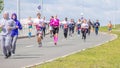 A group of young beautiful sports people run around the new stadium at a city event, race