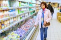 Mature curly woman standing in the dairy department