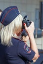 Portrait of a police girl with a camera in her hands at the festival. Text in Russian: police of the Ministry of Internal Affairs