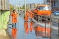 Work janitors wash the sidewalk with a stream of water from a hose on the Moscow Highway on a spring sunny day