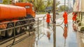 Work janitors wash the sidewalk with a stream of water from a hose on the Moscow Highway on a spring sunny day