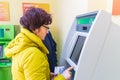 Samara, November 2018: Mature beautiful woman pays utilities through an ATM