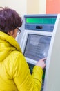 Samara, November 2018: Mature beautiful woman pays utilities through an ATM