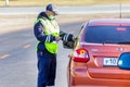 Traffic police officer check driver`s documents on the highway. Russian text: DPS