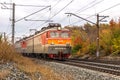 Passenger train with wagons VL10 moves by rail through the beautiful Autumn Forest