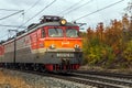 Passenger train with wagons VL10 moves by rail through the beautiful Autumn Forest