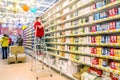 a young woman seller works in a large supermarket with a medical mask during an epidemic