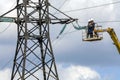 electricians are repairing a high-voltage line against the background of a blue sky Royalty Free Stock Photo