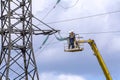 electricians are repairing a high-voltage line against the background of a blue sky Royalty Free Stock Photo