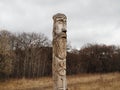 Russia, Saratov - nov,2020: Wooden idol of the Slavic God Perun near the path in the forest. Gloomy forest in the background and