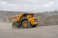 A BelAZ dump truck driving through an open pit mine.