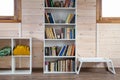 Bookcase with books in a light wooden interior in countryside home