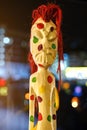 Russia, Sochi 22.12.2021. Ethnic wooden figurine at night. Funny souvenir. Wooden ethnic figurine with a scary grimace