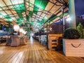 Russia, Sochi 07.22.2019. Evening view of an empty summer cafe with wooden floors, wicker furniture, muted lamps and a Royalty Free Stock Photo