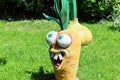 Russia, Sochi 14.05.2022. A funny cartoon carrot with big eyes and crooked teeth adorns the green lawn. Garden figurine.