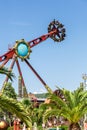 Russia, Sochi 14.05.2022. A giant spinning amusement ride turns people upside down over a southern tropical park