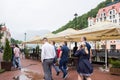 RUSSIA, SOCHI - MAY 25, 2018: Rosa Khutor in the summer, rainy weather. Men and women go near the cafe Royalty Free Stock Photo