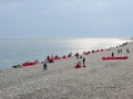 Russia, Sochi 16.04.2021. People rest on armchair bags on the pebble shore along the sea on a cool cloudy day