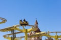 Russia, Sochi 14.05.2022. People in a small yellow open wagon ride on an attraction in an amusement park against the