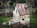 Russia, Sochi 14.03.2020. Small decorative fairytale house on a green lawn with flowers and with a fence behind