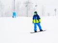 Russia, Sochi 21.01.2020. Snowboarder in a blue suit rides along the track in snowy foggy weather