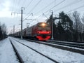 Russia, St. PetersburElectric train following the railroad in winter